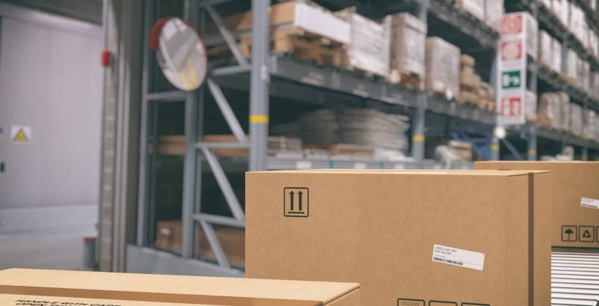 Cardboard boxes on conveyor roller with racks on background